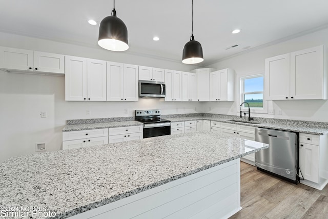 kitchen with light hardwood / wood-style floors, white cabinets, stainless steel appliances, decorative light fixtures, and sink