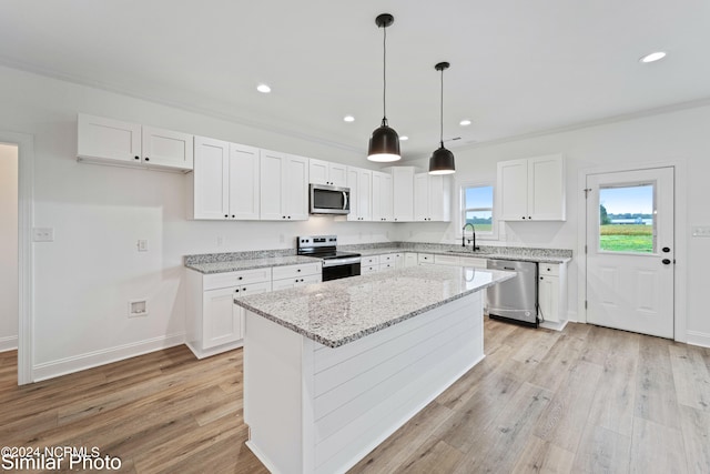 kitchen featuring light hardwood / wood-style flooring, white cabinets, a center island, and appliances with stainless steel finishes