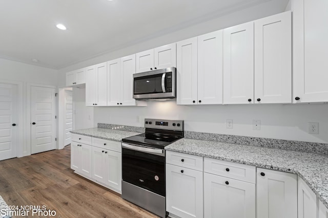 kitchen featuring light stone counters, dark wood-type flooring, stainless steel appliances, and white cabinets