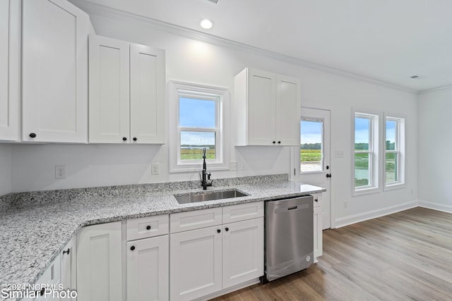 kitchen with light hardwood / wood-style floors, white cabinets, stainless steel dishwasher, ornamental molding, and sink