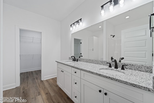 bathroom featuring walk in shower, vanity, and hardwood / wood-style flooring