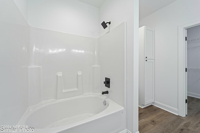 bathroom with wood-type flooring and  shower combination