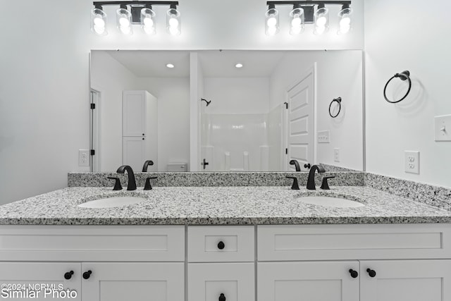 bathroom with walk in shower, vanity, and toilet