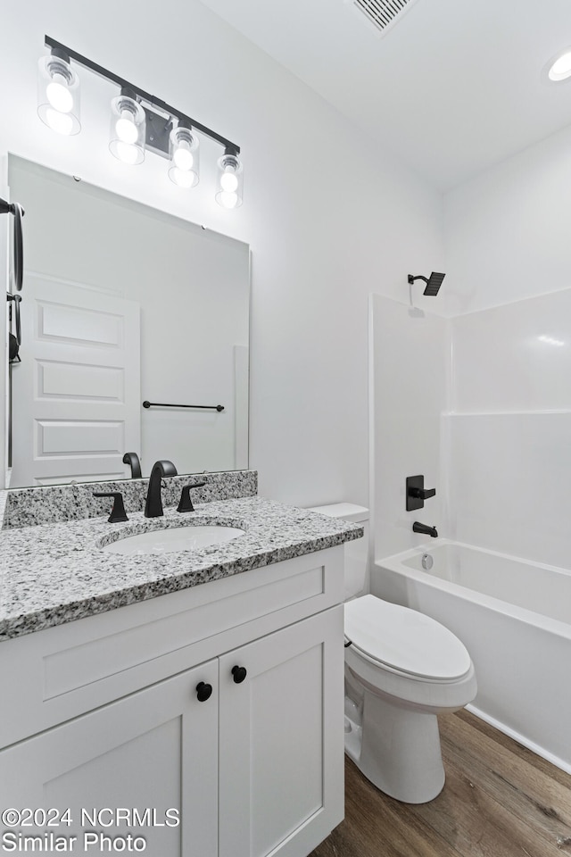 full bathroom featuring tub / shower combination, vanity, hardwood / wood-style floors, and toilet