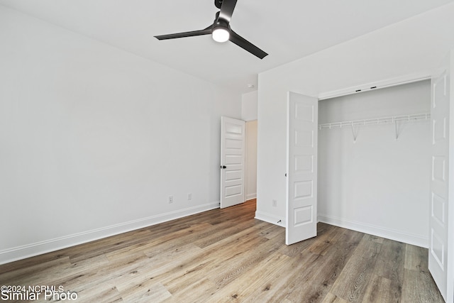 unfurnished bedroom with ceiling fan, a closet, and wood-type flooring