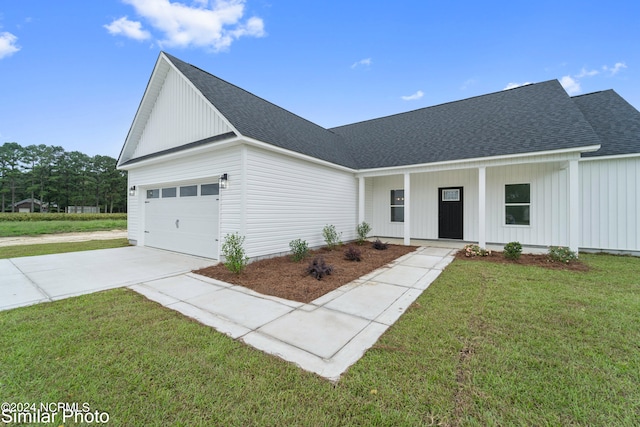 modern farmhouse featuring a front lawn and a garage