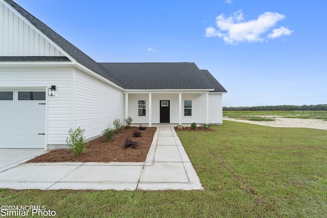 modern farmhouse featuring a front yard and a garage