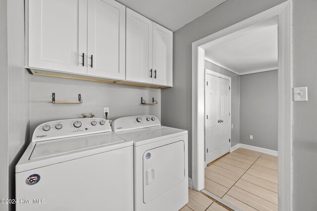 washroom with washing machine and clothes dryer and cabinets