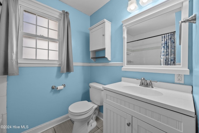 bathroom featuring a shower with curtain, tile patterned flooring, vanity, and toilet