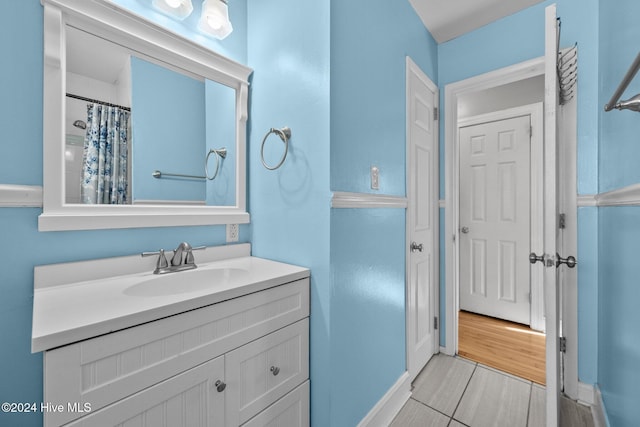 bathroom with hardwood / wood-style floors, vanity, and curtained shower