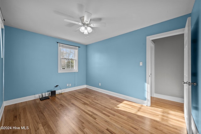 spare room with ceiling fan and light wood-type flooring