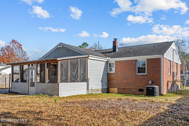 rear view of property featuring central air condition unit and a sunroom