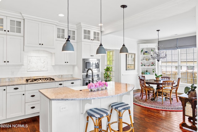 kitchen with white cabinetry, dark hardwood / wood-style flooring, a kitchen island, stainless steel appliances, and backsplash