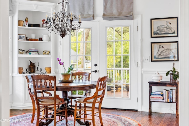 dining room featuring a notable chandelier, a wealth of natural light, and wood-type flooring