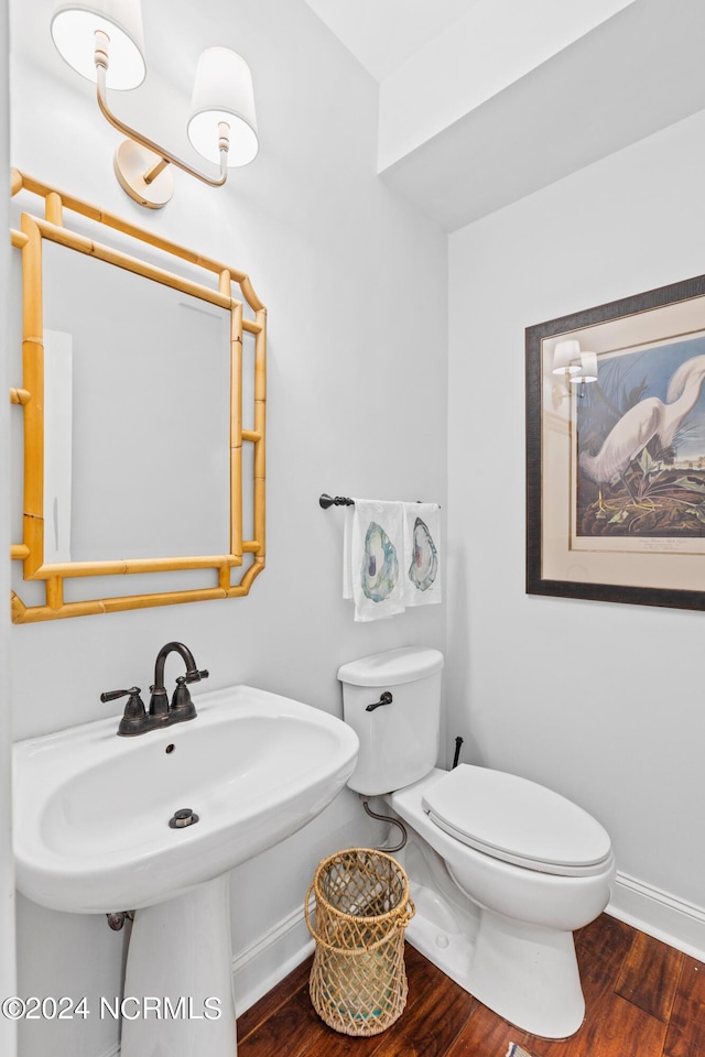 bathroom with hardwood / wood-style flooring and toilet