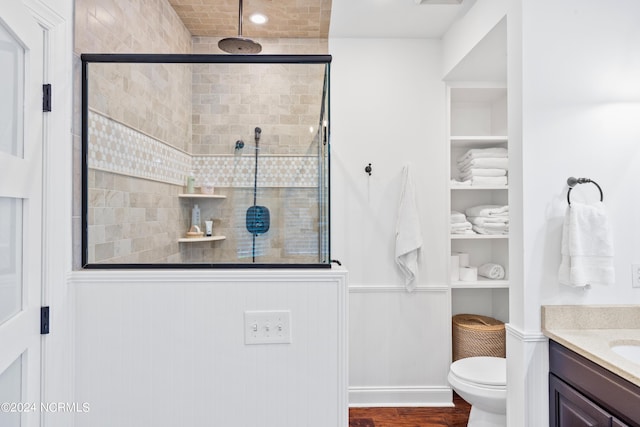 bathroom featuring vanity, hardwood / wood-style flooring, a shower with door, and toilet