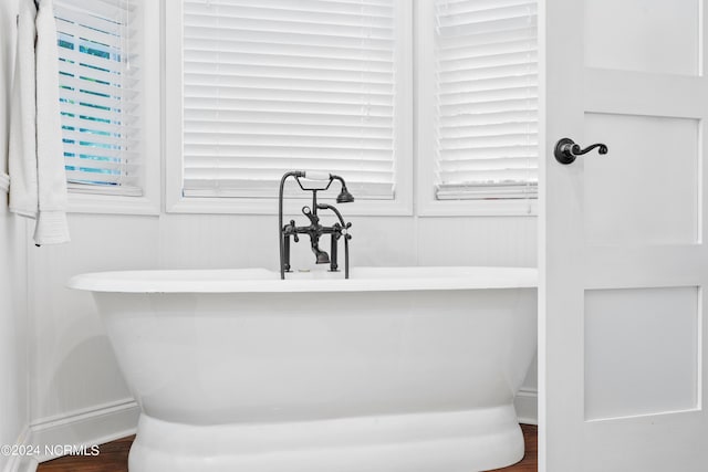 bathroom featuring hardwood / wood-style flooring and a bath