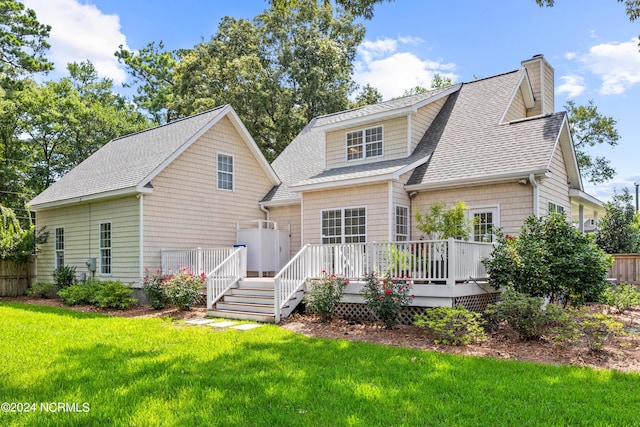 back of property featuring a wooden deck and a lawn