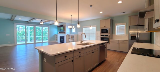 kitchen with gray cabinetry, sink, stainless steel appliances, and beamed ceiling