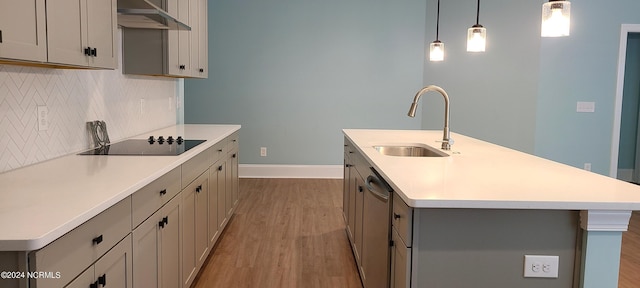 kitchen featuring gray cabinets, pendant lighting, sink, a center island with sink, and black electric cooktop