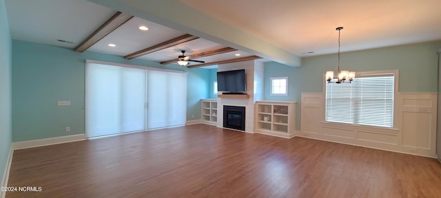 unfurnished living room with dark wood-type flooring, ceiling fan with notable chandelier, a fireplace, and beam ceiling