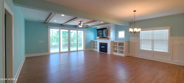 unfurnished living room with beamed ceiling, ceiling fan with notable chandelier, and dark hardwood / wood-style flooring