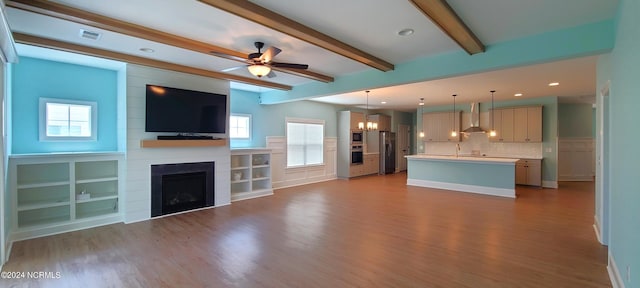 unfurnished living room with beam ceiling, a fireplace, light hardwood / wood-style floors, and ceiling fan with notable chandelier