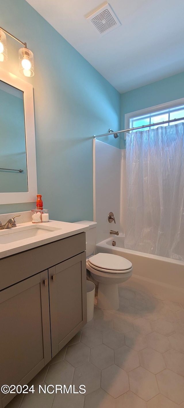 full bathroom featuring tile patterned flooring, vanity, shower / bath combination with curtain, and toilet