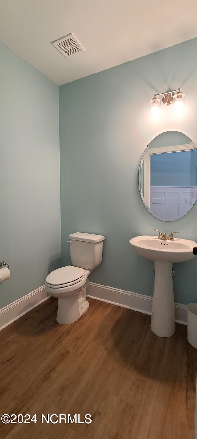 bathroom featuring wood-type flooring and toilet