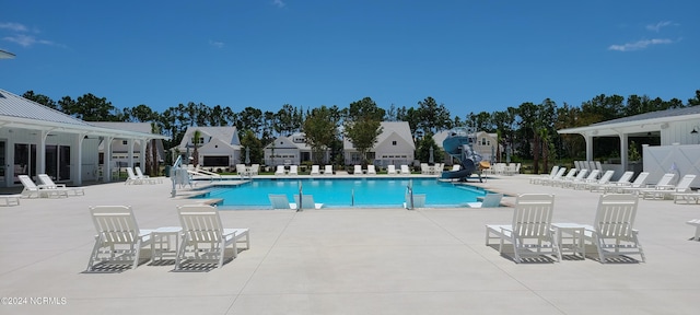 view of swimming pool with a patio and a water slide