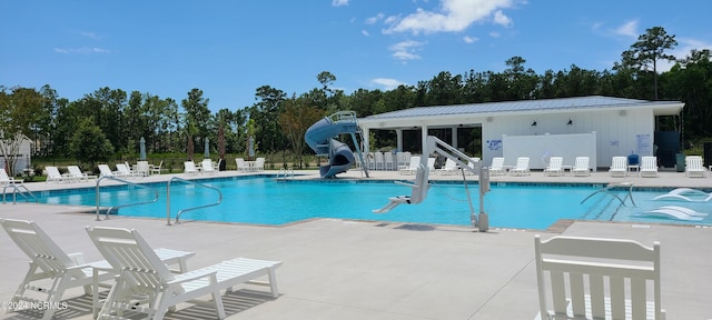 view of swimming pool with a patio and a water slide