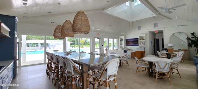 dining room with wood walls, lofted ceiling with beams, wooden ceiling, light tile patterned floors, and ceiling fan