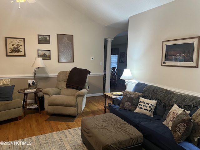 living room featuring hardwood / wood-style floors, vaulted ceiling, and decorative columns