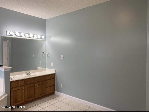 bathroom with tile patterned flooring, vanity, and a textured ceiling