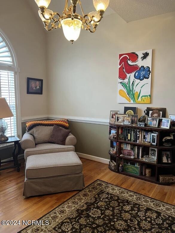 sitting room with an inviting chandelier, hardwood / wood-style floors, and a textured ceiling