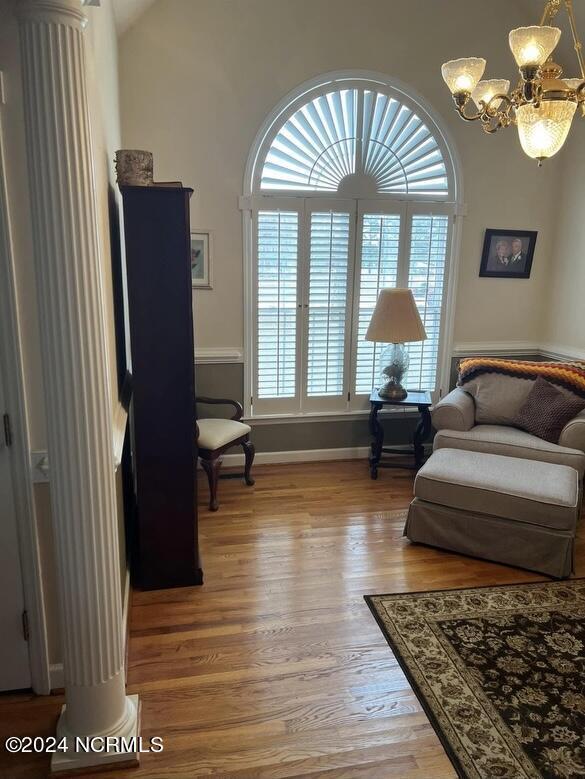 living area with hardwood / wood-style floors and a chandelier