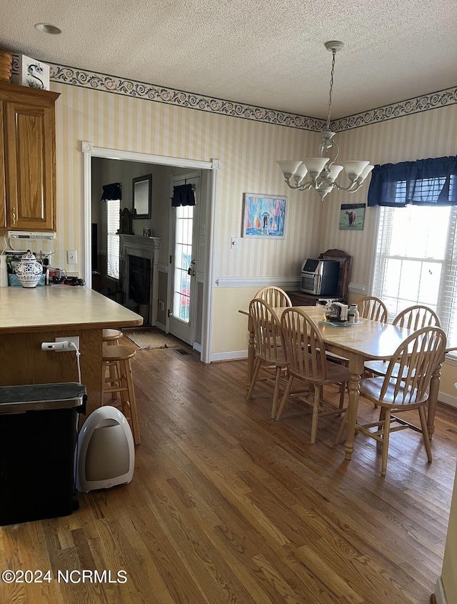 dining space featuring a wealth of natural light, dark hardwood / wood-style floors, and a textured ceiling