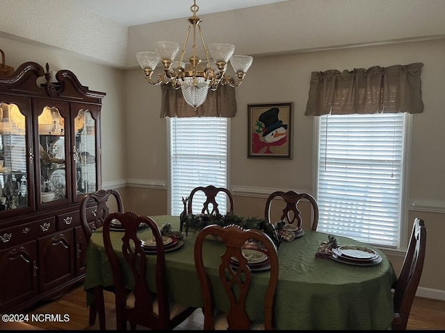 dining space with hardwood / wood-style flooring and an inviting chandelier