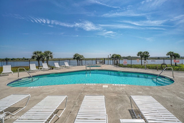 view of swimming pool with a water view and a patio