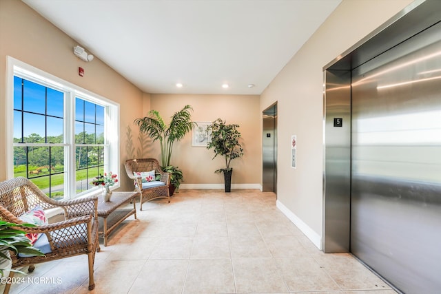 living area with light tile patterned floors and elevator