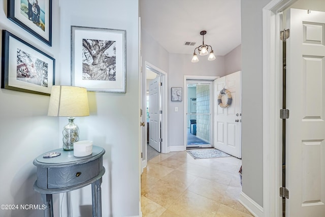 tiled foyer with a notable chandelier