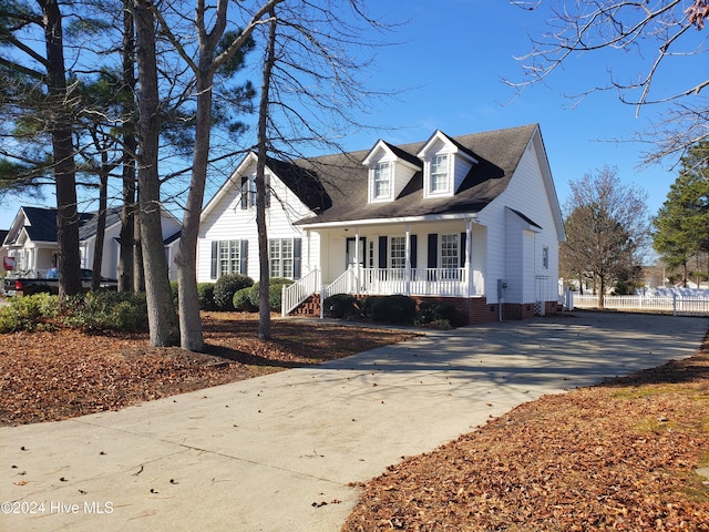 cape cod home featuring covered porch