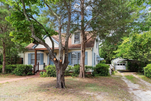 view of front of property featuring a garage, an outdoor structure, and a carport