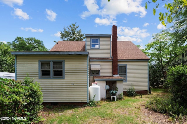 rear view of property featuring a yard