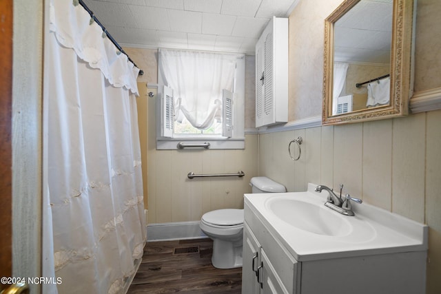 bathroom with toilet, a shower with shower curtain, hardwood / wood-style floors, and vanity