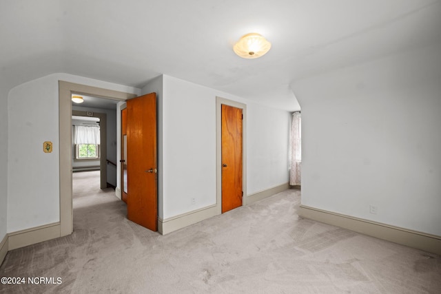 carpeted empty room with a baseboard heating unit