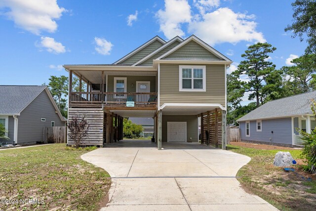 view of front of property with a carport, a front yard, and covered porch