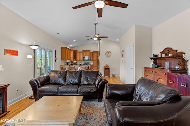 living room with ceiling fan, lofted ceiling, and light hardwood / wood-style floors