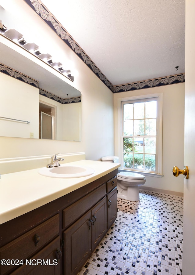 bathroom featuring a textured ceiling, vanity, and toilet