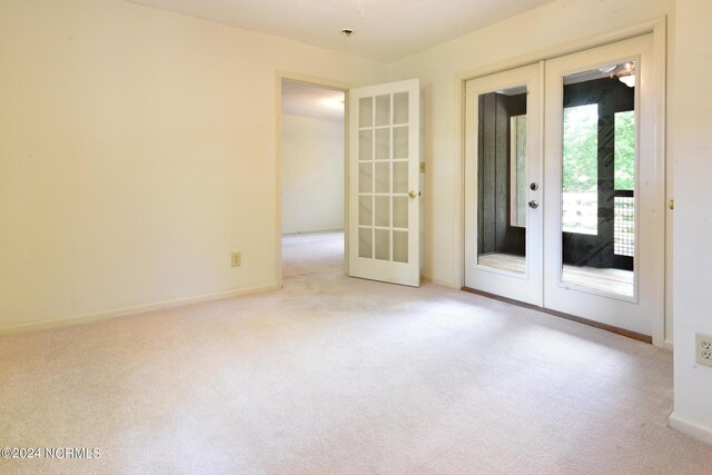 carpeted spare room with french doors and baseboards